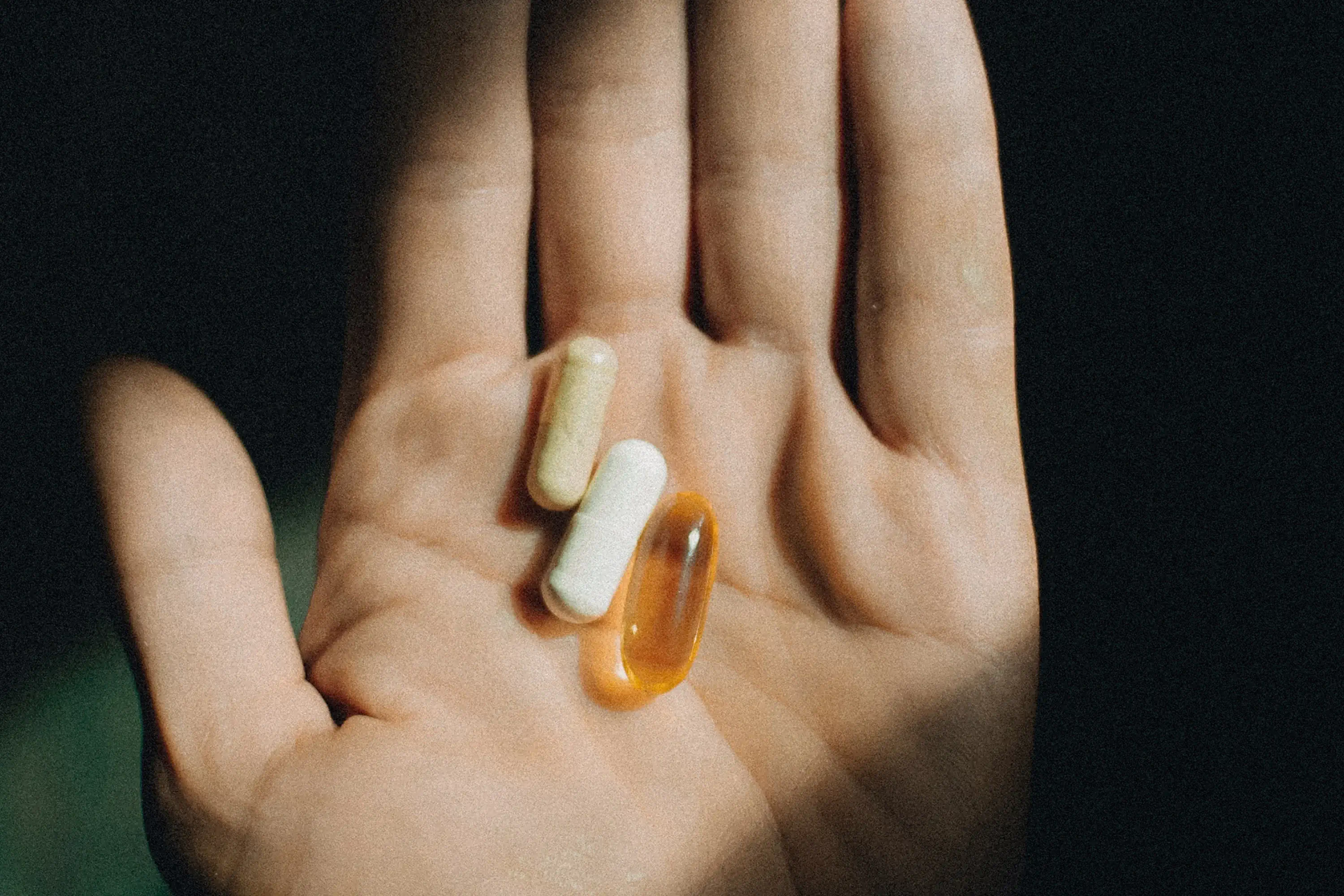 three pills held in the palm of a hand